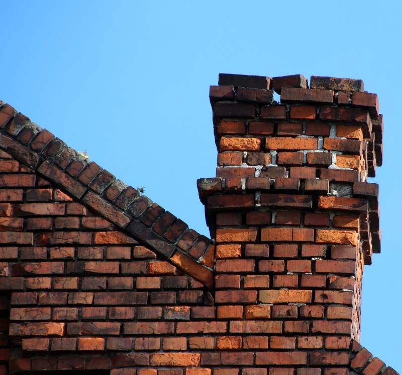 Damaged chimney on an Naperville home showing cracks and missing mortar